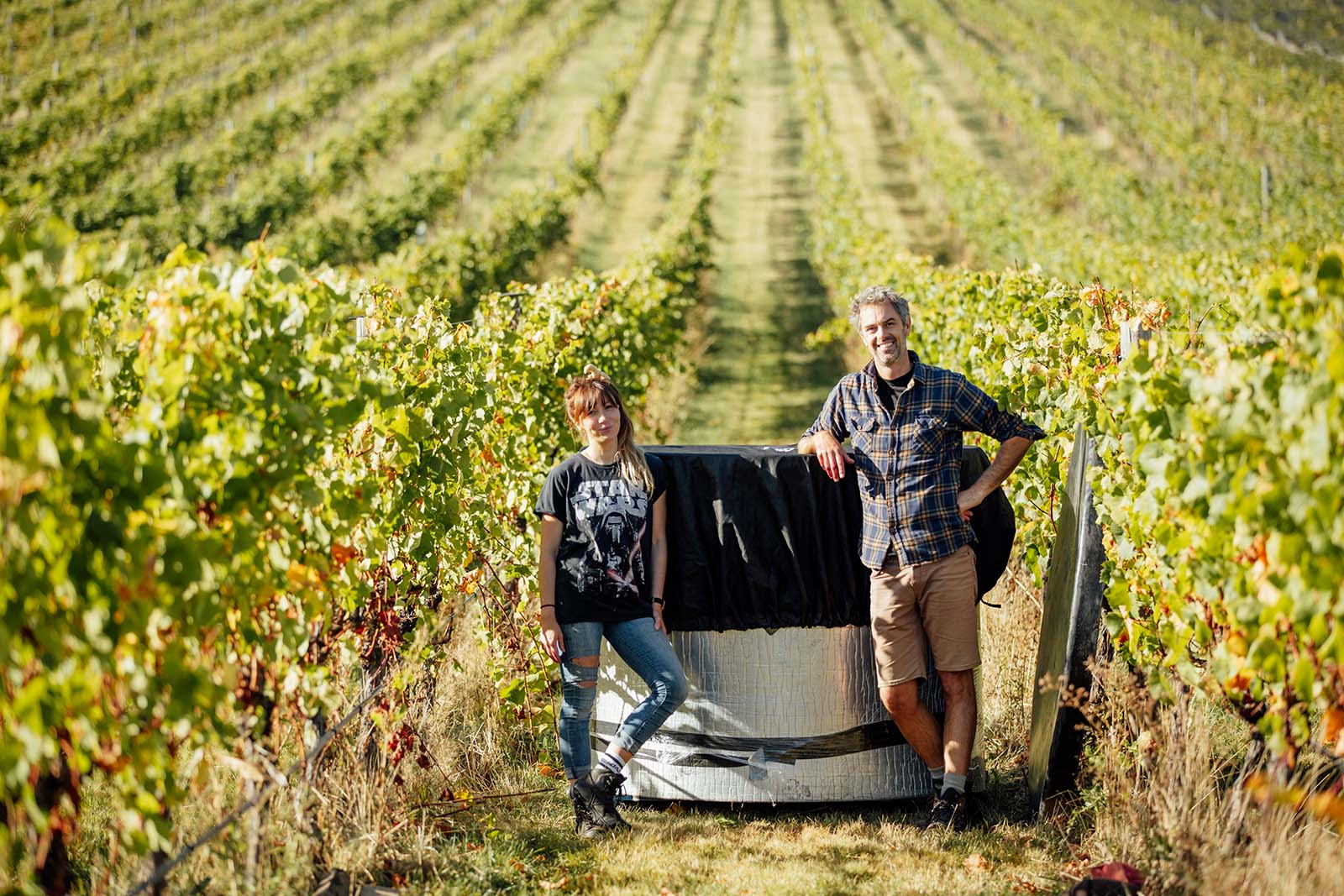 Winemakers standing beside Vineyard Ferment vat