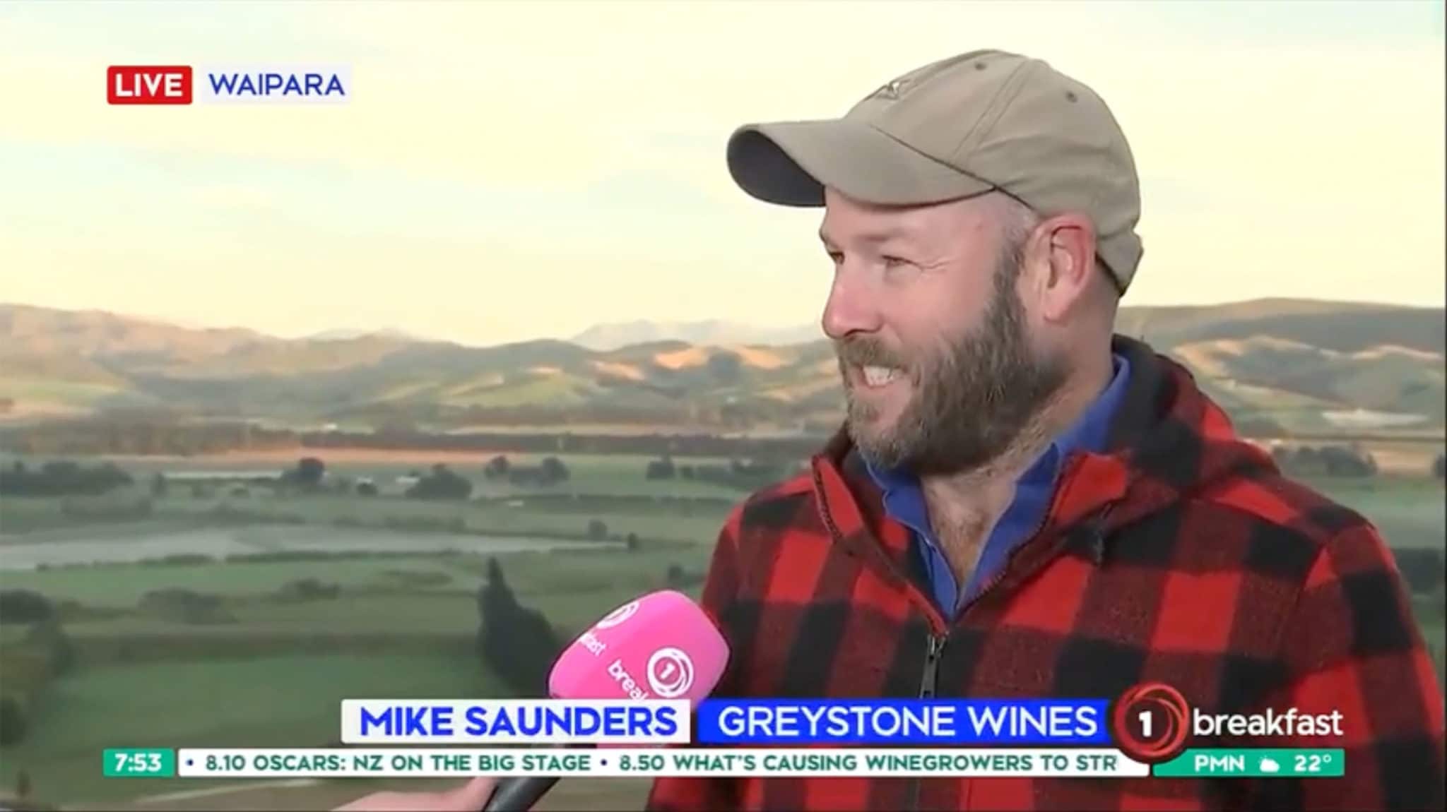 Mike Saunders with microphone overlooking vineyard